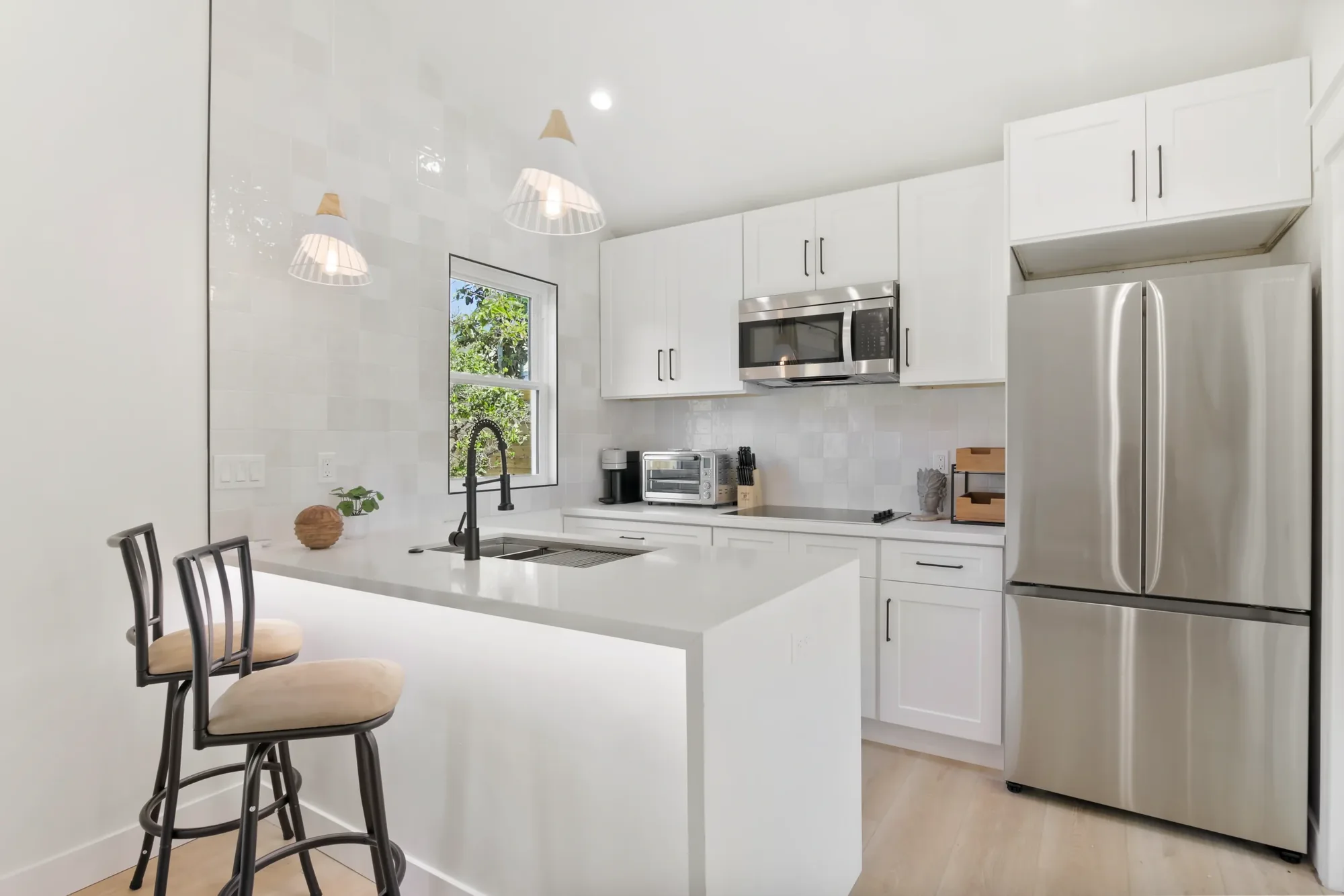 ADU kitchen with island seating and stainless appliances