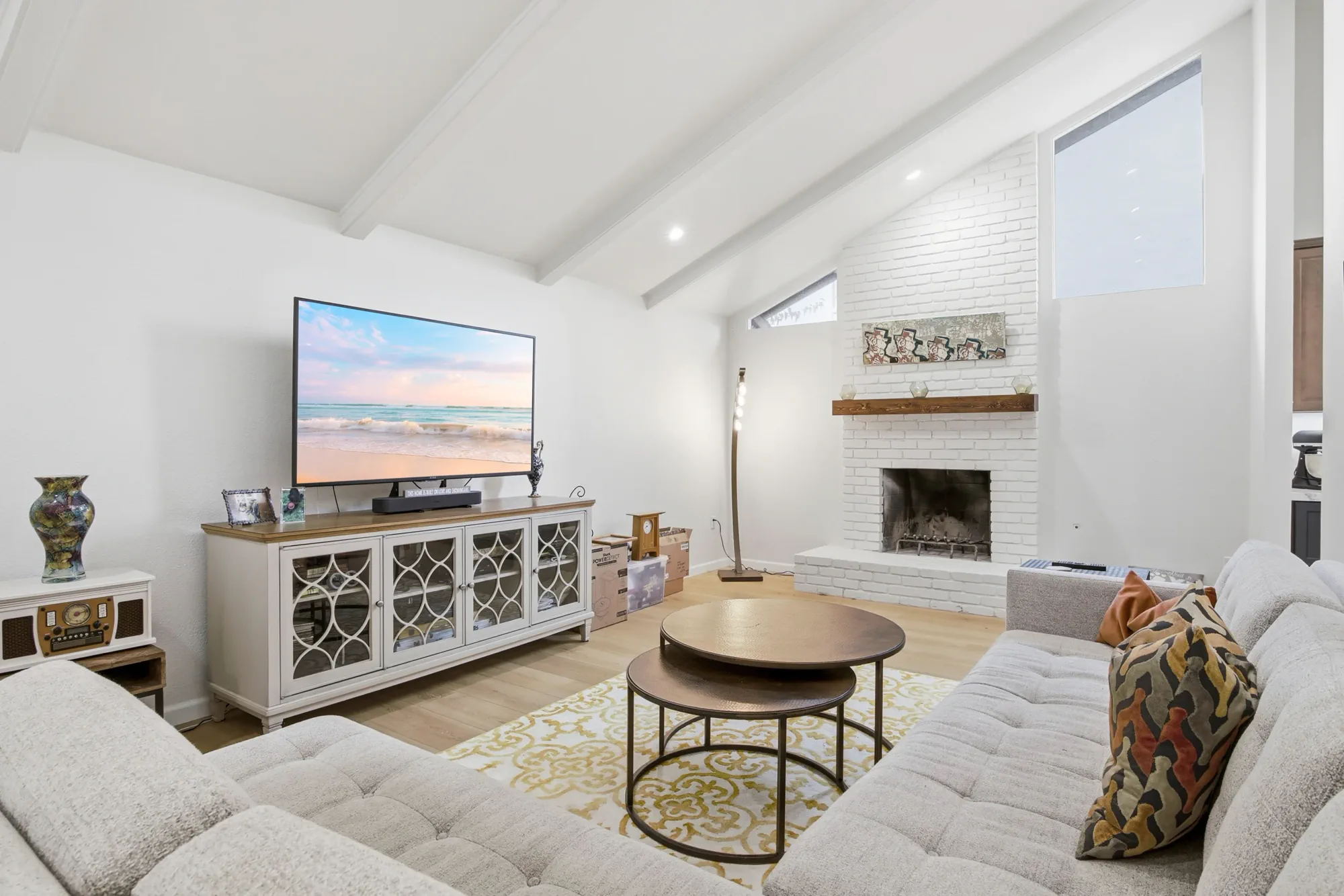 Remodeled living room with white brick fireplace